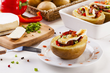 Baked potatoes stuffed with bacon, served with camembert
