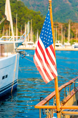 USA flag on the background of the masts of yachts in the port