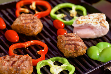 BBQ with burgers, pappers, tomatos and mushrooms