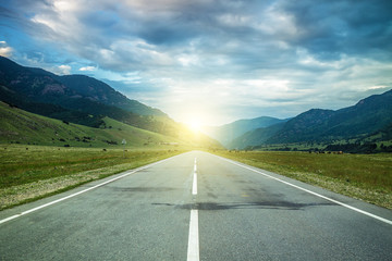 road in summer mountains to the sunset