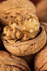 Whole walnuts and walnut kernel in a wicker basket close-up