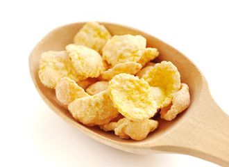 Cornflakes in a wooden spoon on white background