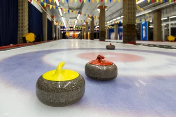 Abwaschbare Fototapete Curlingsteine auf einer Hallenbahn © Sergey Lavrentev