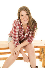 woman red plaid shirt shorts sit lean forward smile