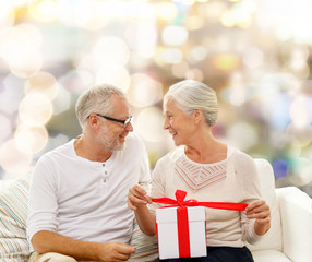 happy senior couple with gift box at home