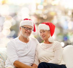 happy senior couple in santa helper hats