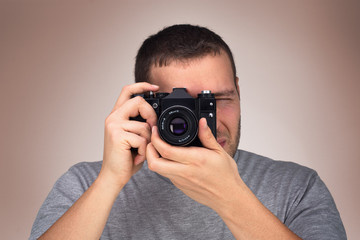 Photographer. Close up portrait of man holding vintage camera.