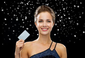 smiling woman in evening dress holding credit card