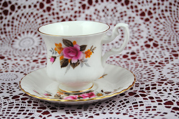 Antieke kop en schotel met bloemen en een gouden randje