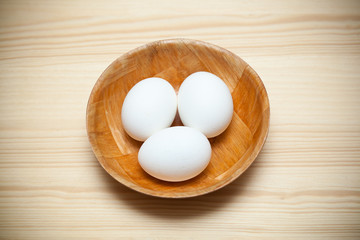 Three white chicken eggs in a plate