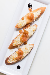 Toast bruschettes topped with cheese and quince jam