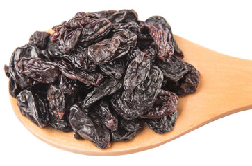 Black raisin on wooden spoon over white background