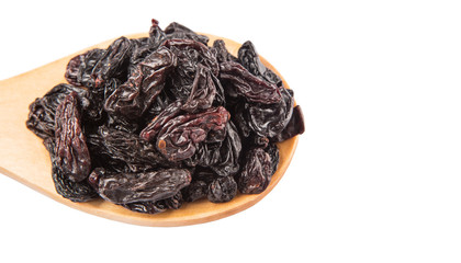 Black raisin on wooden spoon over white background