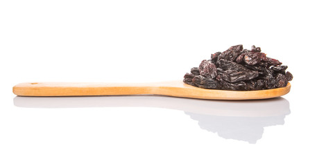 Black raisin on wooden spoon over white background