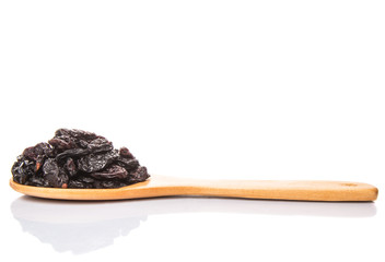 Black raisin on wooden spoon over white background