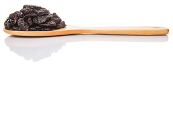 Black raisin on wooden spoon over white background