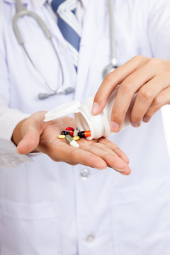 Asian male doctor with pills and pharmacy bottle