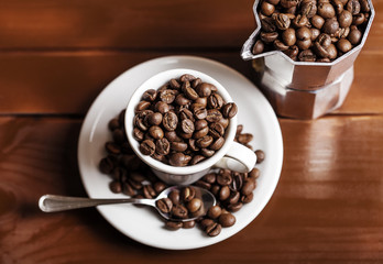 Coffee cup and percolator full of coffee beans