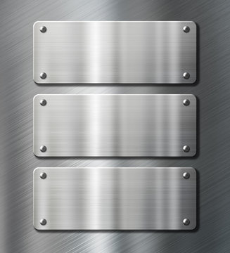three stainless steel metal plates on brushed background