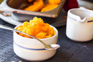 pumpkin puree in a ceramic bowl with spoon, healthy dessert