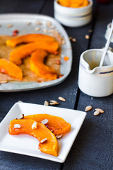 Baked pumpkin with cinnamon and nuts on a white plate