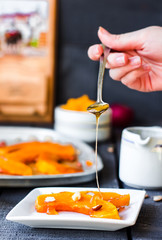 pour honey on a spoon baked pumpkin with walnuts