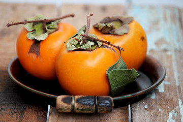 Fresh ripe persimmon on a wooden table