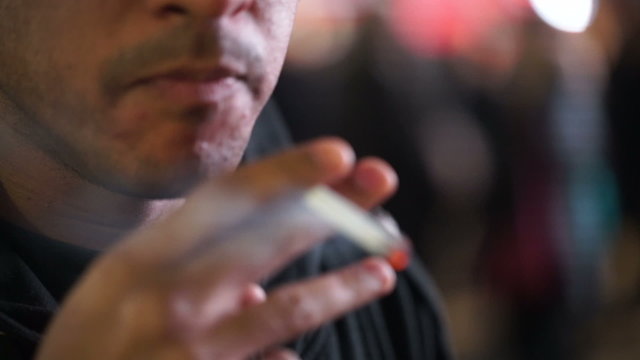 Close up of a man lighting up a cigarette to smoke