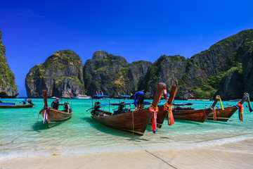 Fototapeta premium Long tail boat on white sand beach with crystal clear sea