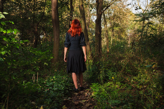 Young redhead woman in the woods