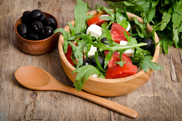 Greek salad in a wooden salad bowl on the table