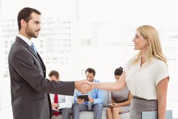 Businessman shaking hands with woman