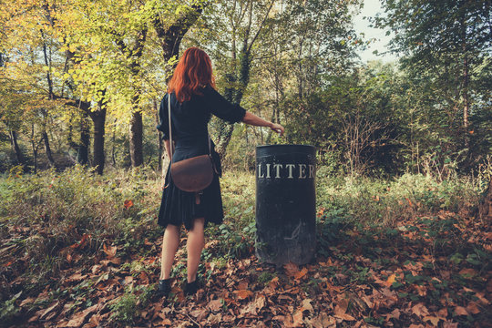 Woman disposing litter in the forest