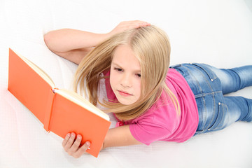 Cute little girl is reading book