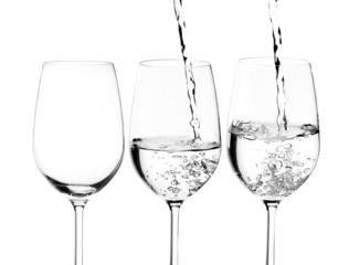 pouring water on a glass on white background