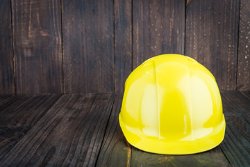 Construction hard hat on wooden background
