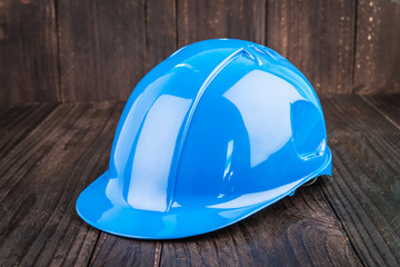 Construction hard hat on wooden background