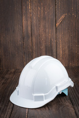 Construction hard hat on wooden background
