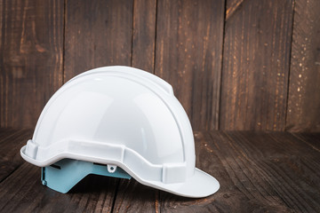 Construction hard hat on wooden background