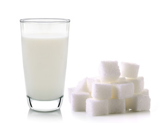 glass of milk and cubes of cane sugar isolated on white backgrou