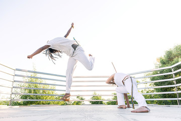 Capoeira, a woman and a man struggling in the outdoors