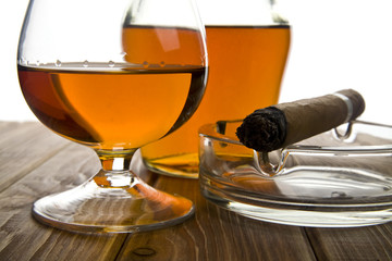 glass and bottle of cognac with a cigar