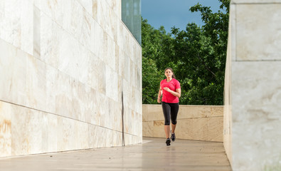 Fototapeta na wymiar Abstract - Beautiful woman running on a modern building at