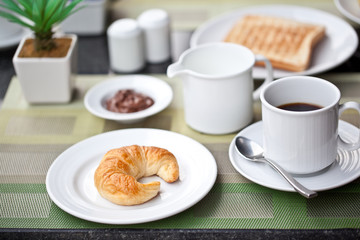 Hotel breakfast. croissant and coffee with milk