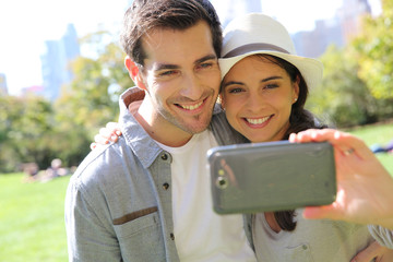 Cheerful couple taking picture of themselves in central park