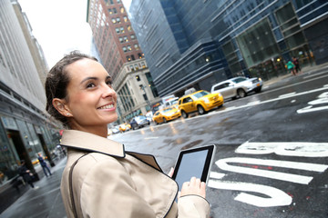 Businesswoman standing in a street of Manhattan with tablet
