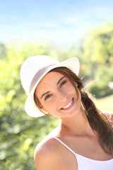 Portrait of beautiful woman with hat in park
