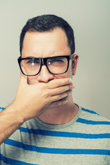 Young man in glasses covered her mouth