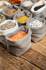 Corn kernel seed meal and grains in bags isolated on a wood tabl