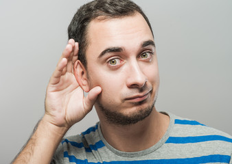 Obraz premium Man holds his hand near his ear and listening something